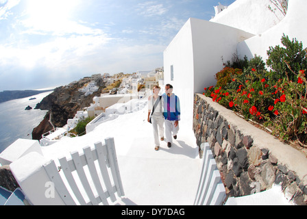 Ein paar genießen Sie einen Spaziergang und die Aussicht in Oia, Santorini, Griechenland. Stockfoto