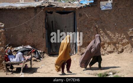 Islamabad, Pakistan. 8. April 2014. Afghanische Flüchtlingsfrauen vorbeigehen ein Lehmhaus in Slumviertel von Islamabad am 8. April 2014. Laut das Flüchtlingshilfswerk der Vereinten Nationen, UNHCR, gibt es rund 2,6 Millionen registrierte Afghanen in Pakistan, von denen meisten gewesen lebt hier seit Anfang der 1980er Jahre als ehemaligen Sowjetunion ihre Heimat eingefallen. Mit wenig Chancen, ihren Lebensunterhalt in Pakistan zu machen wollen sie ihr Haus aber nur zurückkehren, nachdem der Frieden in Afghanistan wieder hergestellt ist. Bildnachweis: Pazifische Presse/Alamy Live-Nachrichten Stockfoto