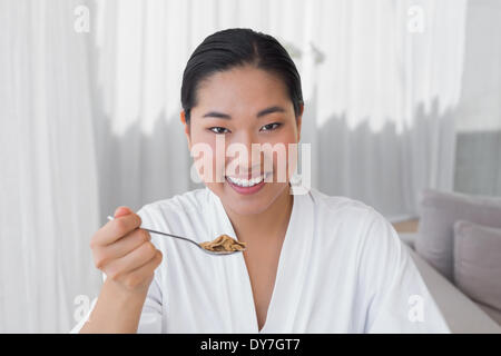 Glückliche Frau im Bademantel frühstücken Sie Ihr Stockfoto