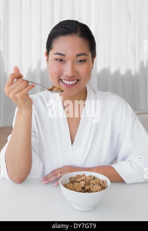 Glückliche Frau im Bademantel frühstücken Sie Ihr Stockfoto