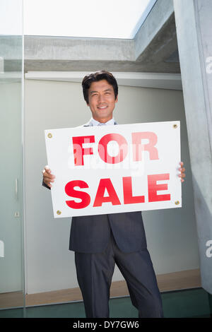 Zuversichtlich Immobilienmakler stehend an Haustür für Verkauf Zeichen anzeigen