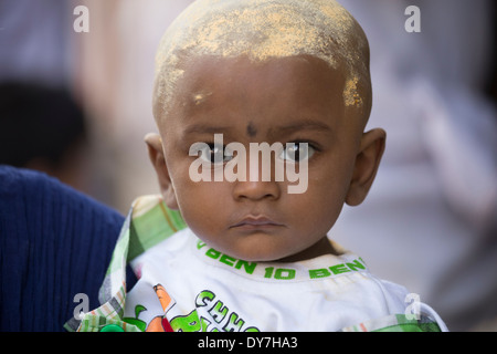 Baby mit Kopf bedeckt in Sandelholz Pulver, während Chithirai Thiruvizha hinduistische Festivals, Madurai, Indien Stockfoto