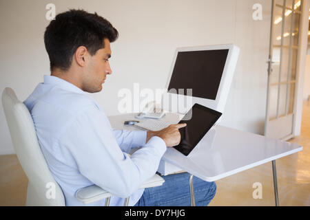 Geschäftsmann, arbeiten auf seinem Tablett an seinem Schreibtisch Stockfoto