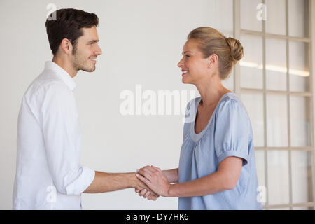 Casual Business-Frau Händeschütteln mit Mann Stockfoto