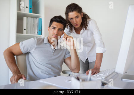 Blick in die Kamera zusammen am Schreibtisch Casual Business-team Stockfoto