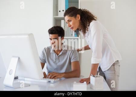 Casual Business-Team Blick auf Computer an der Rezeption Stockfoto