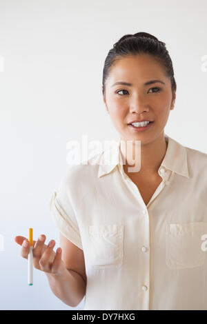 Lässige Geschäftsfrau, die eine elektronische Zigarette rauchen Stockfoto