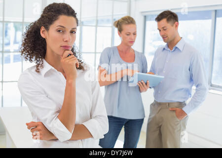 Lässige Geschäftsfrau Blick in die Kamera mit der Hand am Kinn Stockfoto