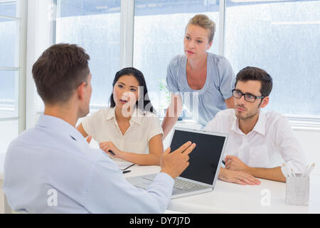 Lässige Geschäftsmann mit seinem Laptop während eines Meetings Stockfoto