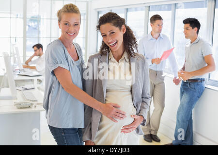 Lässige Geschäftsfrau berühren Bauch schwanger Kollegen Stockfoto