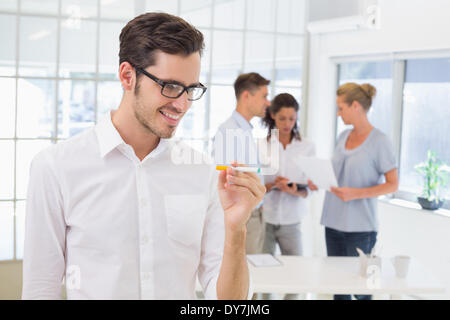 Lässige Geschäftsmann lächelnd an seine elektronische Zigarette Stockfoto