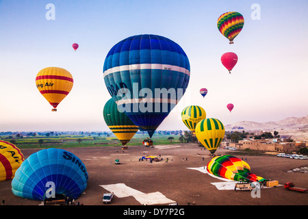 Heißluft Ballons werden aufgeblasen und ausziehen für einen Sonnenaufgang Flug vom Westufer des Nils in Ägypten. Stockfoto