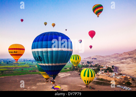 Heißluftballons über dem Westufer des Nils in Ägypten bei Sonnenaufgang fliegen. Stockfoto