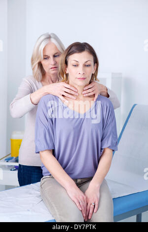 Schilddrüse Abtasten Frau Stockfoto