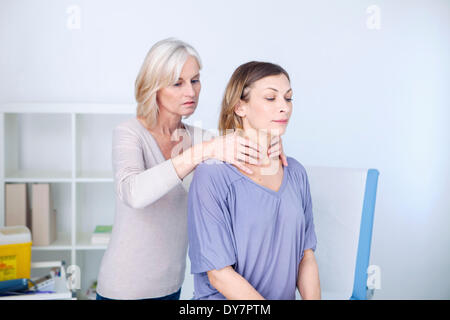 Schilddrüse Abtasten Frau Stockfoto
