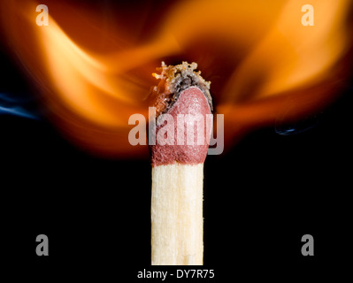 Gleiches leuchten Flamme zeigt an der Stelle, an der Zündung, auf einem schwarzen Hintergrund. Brennendes Streichholz nach entzündet wird. Stockfoto