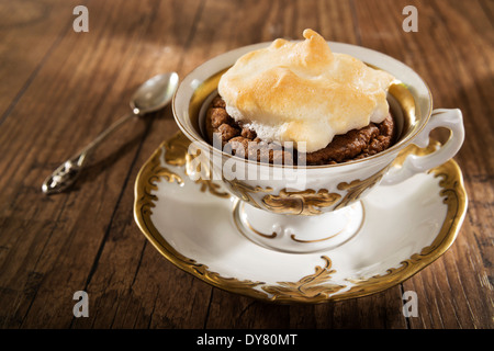 Mandel gebackenen Mokka Tasse Kuchen mit Baiser auf Holztisch Stockfoto