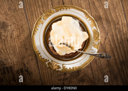 Mandel gebackenen Mokka Tasse Kuchen mit Baiser auf Holztisch, erhöhten Blick Stockfoto