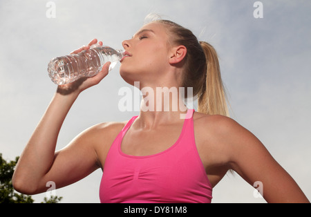 Porträt der jungen blonden Fitness Läufer trinken aus der Flasche Wasser Stockfoto