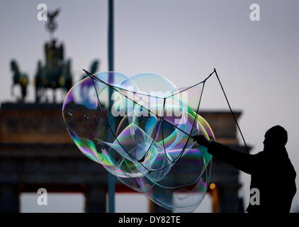 Berlin, Deutschland. 29. März 2014. Eine Straße Künstler bildet große Seifenblasen vor dem Brandenburger Tor am Pariser Platz-Platz in Berlin, Deutschland, 29. März 2014. Foto: Soeren Stache/Dpa/Alamy Live News Stockfoto
