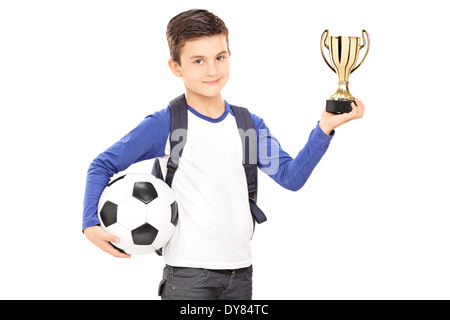 Kleine Schüler halten Fußball und eine Trophäe Stockfoto