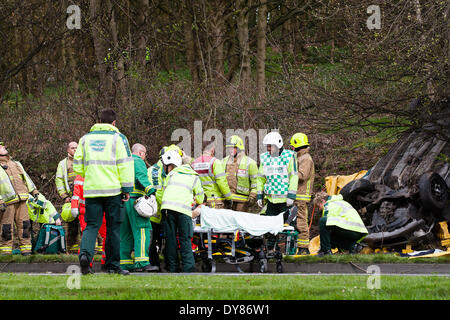 Queenswood Fahrt, Leeds West Yorkshire UK 9. April 2014. Notdienste besuchen einen Vorfall bei rund 1400 Stunden in dem ein Fahrzeug in einem belebten Vorort Straße aufgehoben. Zwei Personen wurden freigeschnitten aus dem Fahrzeug landete auf dem Dach im Wald an der Seite der Straße im Bereich Becketts Park LS6 und aus der Szene entfernt mit einem Krankenwagen. West Yorkshire Air Ambulance auch besuchte die Szene aber wurde nicht verwendet, um Verluste zu transportieren. Ein anderes Fahrzeug, eine gelbe Seat Ibiza, die gesehen wurde, beschädigt zu sein war auch in der Nähe geparkt. Bildnachweis: Ian Wray/Alamy Live-Nachrichten Stockfoto