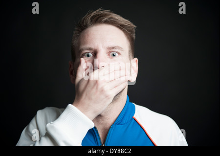 Mann, der Hand an den Mund hält Stockfoto