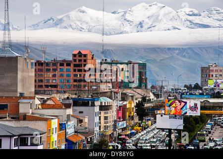 Schnee bedeckte Gipfeln der Anden, mit einem Autobahn-Stau im Vordergrund, in der Stadt El Alto, Bolivien zu sehen sind. Stockfoto