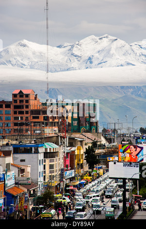 Schnee bedeckte Gipfeln der Anden, mit einem Autobahn-Stau im Vordergrund, in der Stadt El Alto, Bolivien zu sehen sind. Stockfoto