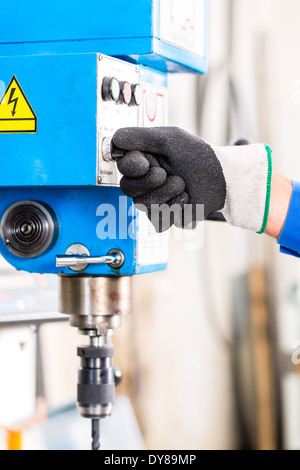 Handwerker, Bohren von Metall mit Bohrer in Werkstatt Stockfoto