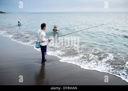 Lokale Fischer im Meer stehen, halten Sie eine Angelrute zum Fang der Insel Lombok, kleinen Sunda-Inseln, Indonesien, Asien Stockfoto