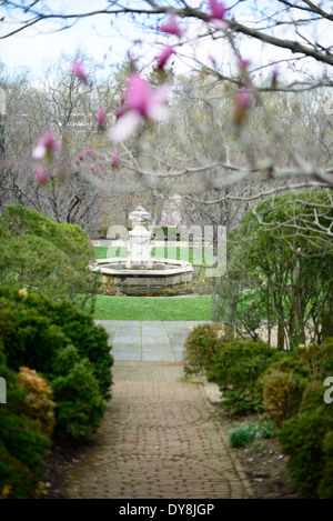Dumbarton Oaks Gardens Fountain Washington DC / WASHINGTON DC, USA – Ein Steinbrunnen steht im Herzen einer der Gartenterrassen von Dumbarton Oaks, wo Wasserspiele jede der wichtigsten kompositorischen Achsen ankern, die Beatrix Farrand für das Anwesen Georgetown errichtet hat. Die Terrassenfolge, die von der Orangerie über die Green Terrace zur Fountain Terrace verläuft, stellt die primäre Achse des oberen Gartens dar, wobei Wasser- und Steinornamente in wichtigen Intervallen visuelle Interpunktion bieten. Farrand begann 1921 mit dem Entwurf und blieb drei Jahrzehnte lang tätig Stockfoto