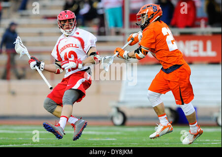 Ithaca, New York, USA. 8. April 2014. 8. April 2014: Cornell Big Red Mittelfeldspieler Joe Paoletta (12) steuert den Ball gegen die Verteidigung von Syracuse Orange Mittelfeldspieler Mike Messina (21), während eine NCAA Männer Lacrosse Spiel zwischen den Syracuse Orange und die Cornell Big Red bei Schoellkopf Field in Ithaca, New York. Syrakus gewann das Spiel 14-9. Rich Barnes/CSM/Alamy Live-Nachrichten Stockfoto