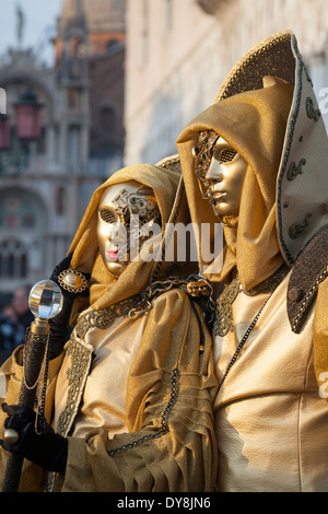 Maskierte paar im goldenen Kostüme auf dem Markusplatz während der Karneval von Venedig Stockfoto