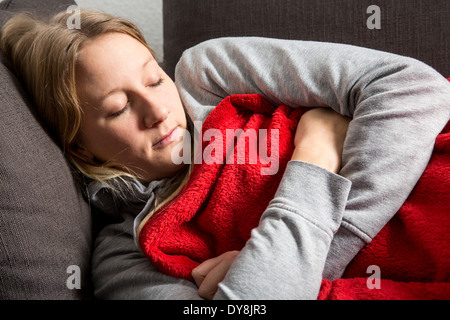 Junge Frau fühlt sich unwohl, entspannen auf dem sofa Stockfoto