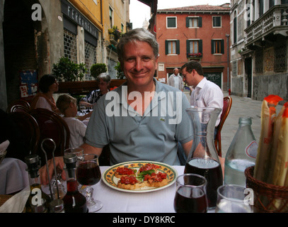 Über 50 Mann genießen Mahlzeit auf der Terrasse des Restaurants in Venedig, Italien. Stockfoto