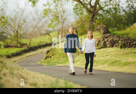 Happy mittleren gealterten Liebespaar zu Fuß auf wunderschönen Country road Stockfoto