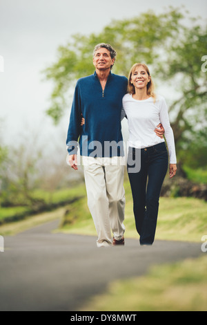 Happy mittleren gealterten Liebespaar zu Fuß auf wunderschönen Country road Stockfoto
