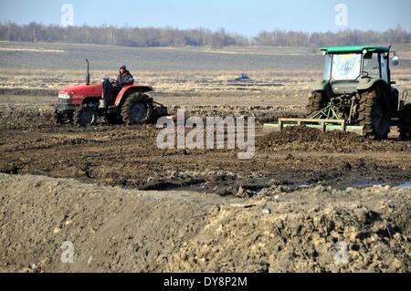 Heihe, Chinas Provinz Heilongjiang. 9. April 2014. Menschen arbeiten auf einem Bauernhof in Heilongjiang Reclamation Area in Heihe, Nordost-China Provinz Heilongjiang, 9. April 2014. Heilongjiang Reclamation Area, auf einer Fläche von etwa 2,4 Millionen Hektar, ist die größte staatliche Farm und auch die wichtige Basis der marktfähigen Korn in China. © Zhou Liangjun/Xinhua/Alamy Live-Nachrichten Stockfoto