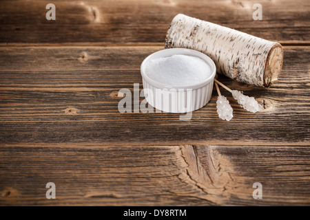 Xylit in Schüssel auf alten hölzernen Hintergrund weiß Stockfoto