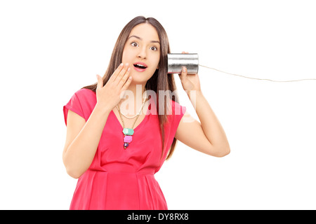 Frau, die etwas über eine Blechdose Telefon hören Stockfoto