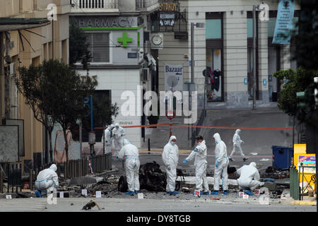 Athen, Griechenland. 10. April 2014. Bombe Beseitigung Polizeiexperten suchen Beweise neben bleibt eines Autos nach der Explosion einer Autobombe in Zentral-Athen, Griechenland, am 10. April 2014. Eine Autobombe explodiert außerhalb der griechischen Zentralbank im Zentrum von Athen frühen Donnerstagmorgen, Schäden an nahe gelegenen Büros, Geschäfte und Autos. Keine Verletzungen wurden berichtet. Der Vorfall kam zu einem Zeitpunkt, wenn Griechenland gegründet wurde, um seine Rückkehr zu machen, später Donnerstag zu internationalen Anleihemärkten zum ersten Mal seit Beginn der Krise im Jahr 2010 durch das Angebot von fünf-Jahres-Anleihen an Investoren. Bildnachweis: Xinhua/Alamy Live-Nachrichten Stockfoto