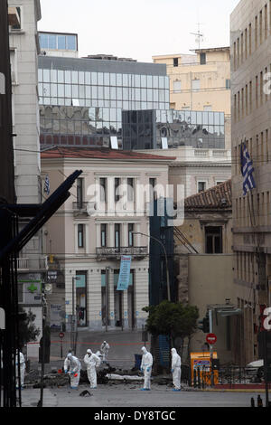 Athen, Griechenland. 10. April 2014. Bombe Beseitigung Polizeiexperten suchen Beweise neben bleibt eines Autos nach der Explosion einer Autobombe in Zentral-Athen, Griechenland, am 10. April 2014. Eine Autobombe explodiert außerhalb der griechischen Zentralbank im Zentrum von Athen frühen Donnerstagmorgen, Schäden an nahe gelegenen Büros, Geschäfte und Autos. Keine Verletzungen wurden berichtet. Der Vorfall kam zu einem Zeitpunkt, wenn Griechenland gegründet wurde, um seine Rückkehr zu machen, später Donnerstag zu internationalen Anleihemärkten zum ersten Mal seit Beginn der Krise im Jahr 2010 durch das Angebot von fünf-Jahres-Anleihen an Investoren. Bildnachweis: Xinhua/Alamy Live-Nachrichten Stockfoto