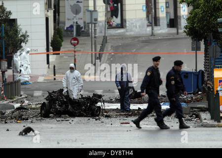 Athen, Griechenland. 10. April 2014. Bombe Beseitigung Polizeiexperten suchen Beweise neben bleibt eines Autos nach der Explosion einer Autobombe in Zentral-Athen, Griechenland, am 10. April 2014. Eine Autobombe explodiert außerhalb der griechischen Zentralbank im Zentrum von Athen frühen Donnerstagmorgen, Schäden an nahe gelegenen Büros, Geschäfte und Autos. Keine Verletzungen wurden berichtet. Der Vorfall kam zu einem Zeitpunkt, wenn Griechenland gegründet wurde, um seine Rückkehr zu machen, später Donnerstag zu internationalen Anleihemärkten zum ersten Mal seit Beginn der Krise im Jahr 2010 durch das Angebot von fünf-Jahres-Anleihen an Investoren. Bildnachweis: Xinhua/Alamy Live-Nachrichten Stockfoto