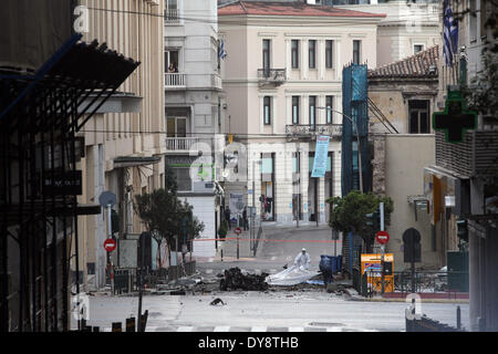 Athen, Griechenland. 10. April 2014. Bombe Beseitigung Polizeiexperten suchen Beweise neben bleibt eines Autos nach der Explosion einer Autobombe in Zentral-Athen, Griechenland, am 10. April 2014. Eine Autobombe explodiert außerhalb der griechischen Zentralbank im Zentrum von Athen frühen Donnerstagmorgen, Schäden an nahe gelegenen Büros, Geschäfte und Autos. Keine Verletzungen wurden berichtet. Der Vorfall kam zu einem Zeitpunkt, wenn Griechenland gegründet wurde, um seine Rückkehr zu machen, später Donnerstag zu internationalen Anleihemärkten zum ersten Mal seit Beginn der Krise im Jahr 2010 durch das Angebot von fünf-Jahres-Anleihen an Investoren. Bildnachweis: Xinhua/Alamy Live-Nachrichten Stockfoto