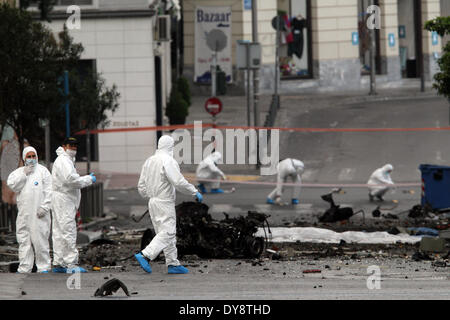 Athen, Griechenland. 10. April 2014. Bombe Beseitigung Polizeiexperten suchen Beweise neben bleibt eines Autos nach der Explosion einer Autobombe in Zentral-Athen, Griechenland, am 10. April 2014. Eine Autobombe explodiert außerhalb der griechischen Zentralbank im Zentrum von Athen frühen Donnerstagmorgen, Schäden an nahe gelegenen Büros, Geschäfte und Autos. Keine Verletzungen wurden berichtet. Der Vorfall kam zu einem Zeitpunkt, wenn Griechenland gegründet wurde, um seine Rückkehr zu machen, später Donnerstag zu internationalen Anleihemärkten zum ersten Mal seit Beginn der Krise im Jahr 2010 durch das Angebot von fünf-Jahres-Anleihen an Investoren. Bildnachweis: Xinhua/Alamy Live-Nachrichten Stockfoto