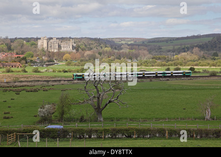 Ein Zug des Südens fährt vor dem historischen Arundal Castle, West Sussex, Großbritannien, vorbei. Der South Downs National Park im Hintergrund Stockfoto