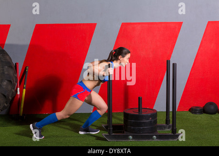 Schlitten schieben Frau drücken Gewichte Training Übung im Fitnessstudio Stockfoto