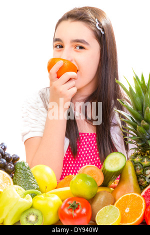 Kleines Mädchen mit Früchten - fröhliches Mädchen mit Früchten-Sortiment auf dem Tisch. Stockfoto