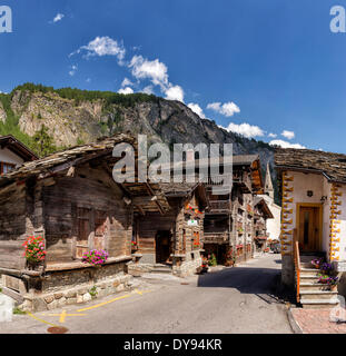 Antike alte Holzhäuser Chalets Stadt Dorf Blumen Sommer Berge Hügeln Evolene Val Hérens Wallis Wallis Schweiz Stockfoto